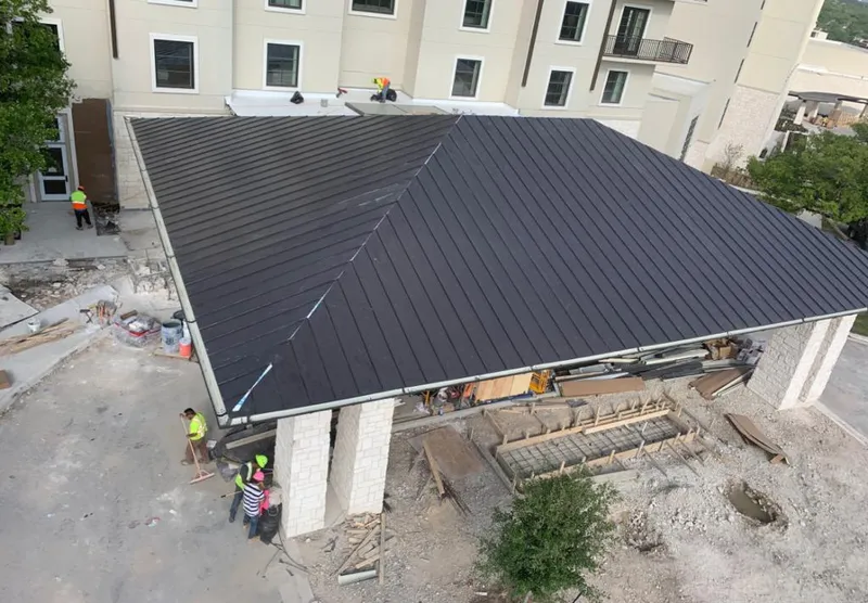 Metal roofing installation team working on a commercial building in Woolwich